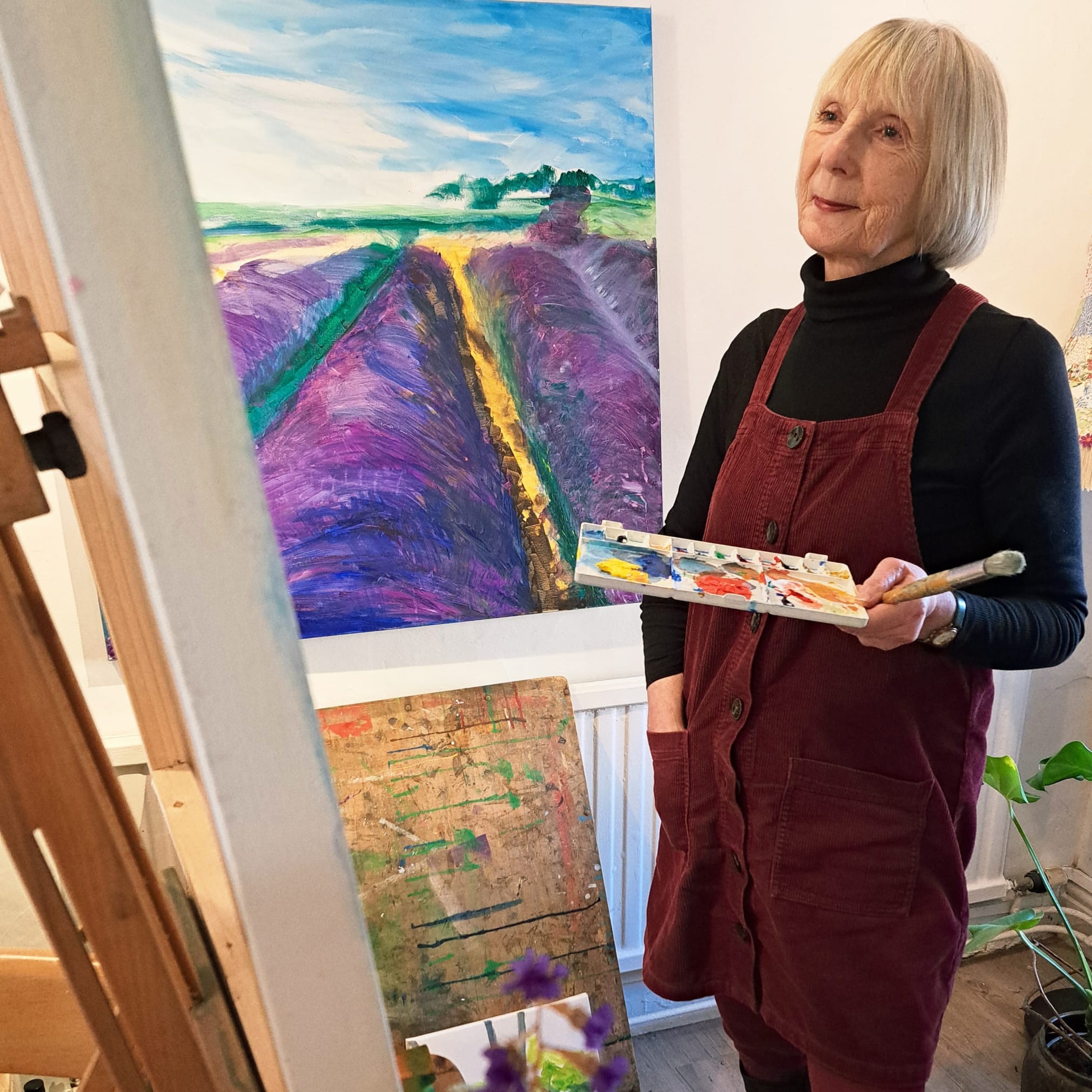 Jan LAMPS artist in residence standing next to her artwork